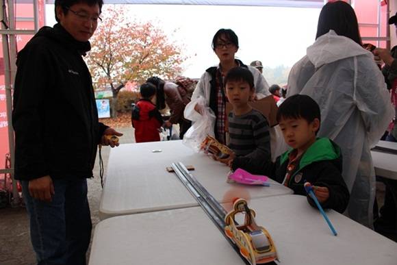 한국기계연구원 부스에 마련된 자기부상열차 모형 만들기에 참가한 가족이 직접 만든 모형 자기부상열차를 운전하고 있는 모습. 