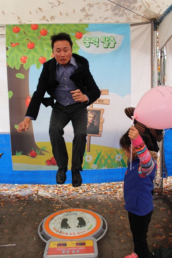아빠의 중력 탈출. 한국표준과학연구원이 마련한 '중력탈출 체험' 프로그램에 참여한 한 남성 참가자가 아이 앞에서 힘껏 점프하고 있다. 아이와 달리 아빠의 표정은 사뭇 진지(?)하다. 