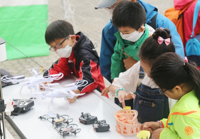 팹트럭에서 3D프린터로 제작한 드론에 어린이 참가자들이 관심을 보이고 있다.<사진=대덕넷>
