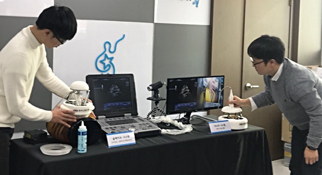 서준호 박사(인물 오른쪽) 연구팀이 래디우스(RADIUS) 시스템의 마스터 로봇(로봇 오른쪽)과 슬레이브 로봇(로봇 왼쪽)을 이용해 원격 의료영상 진료 시연을 보이고 있다.<사진=길애경 기자>