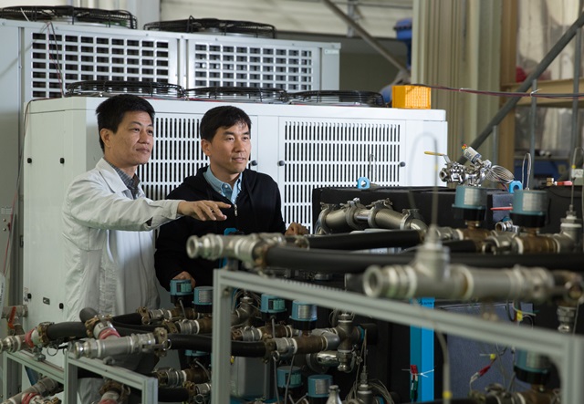 권오경 그룹장(오른쪽)과 박인 수석연구원(왼쪽)이 개발한 흡착식 냉동기 시제품의 작동상태를 살펴보고 있다.<사진=한국생산기술연구원 제공>