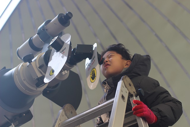 "조금 더 자세히 보고싶어요" 백성현 어린이가 천체망원경을 통해 부분일식을 관람중이다. <사진 = 홍성택 수습기자>