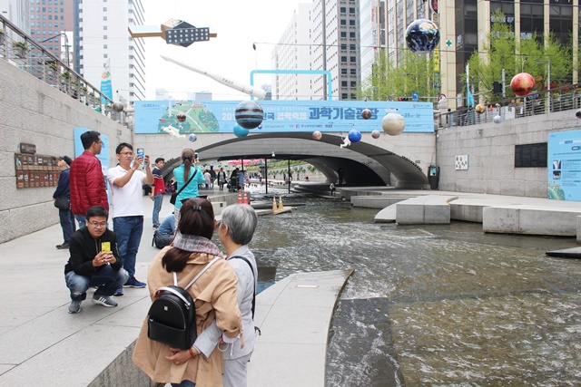 19일부터 23일까지 '2019 대한민국 과학축제'가 서울 도심속에서 열리고 있다. 청계천을 따라 산책을 하는 시민들이 과학전시를 감상하며 과학을 느끼고 있다. <사진 = 홍성택 기자>