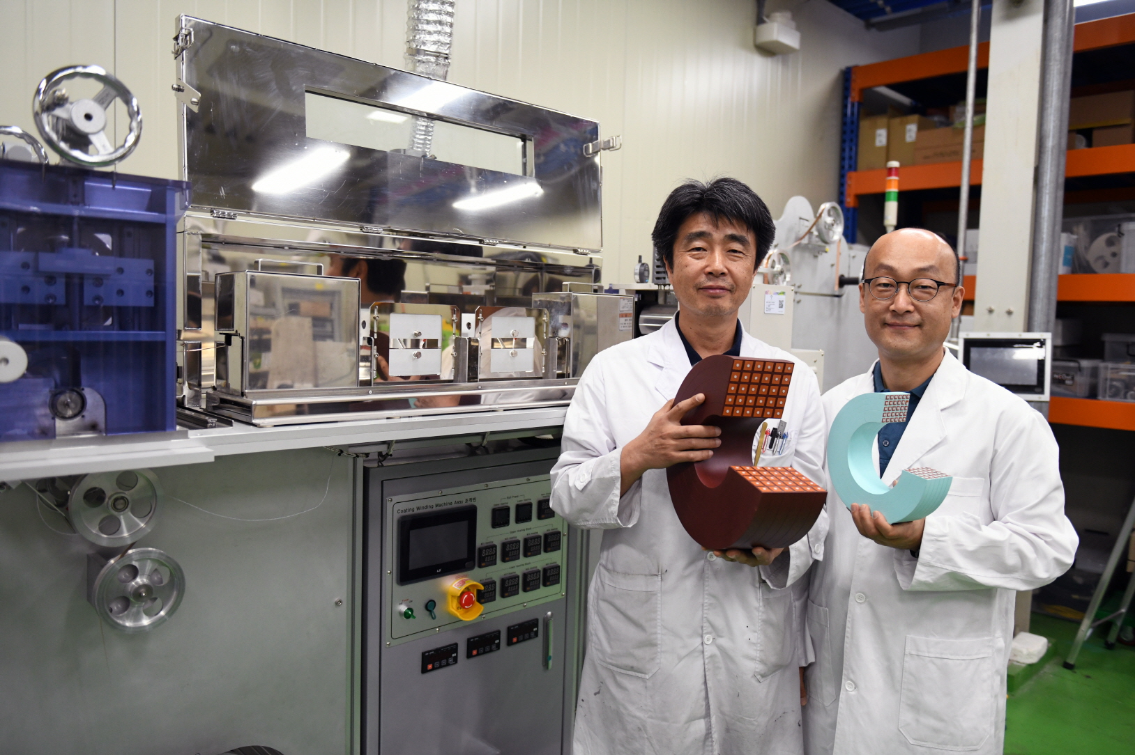 김석환 박사(왼쪽)와 조영식 박사가 크기와 무게가 줄어든 초전도 전자석 모형을 들고 있다. <사진=전기연 제공>