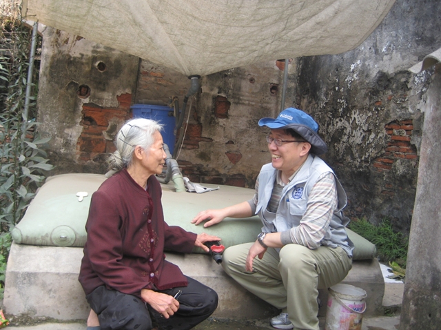 베트남 라이샤 마을의 한 가정에 설치된 빗물 식수화 시설 앞에서 할머니와 대화를 나누고 있는 한무영 교수 .<사진=서울대 빗물연구센터>