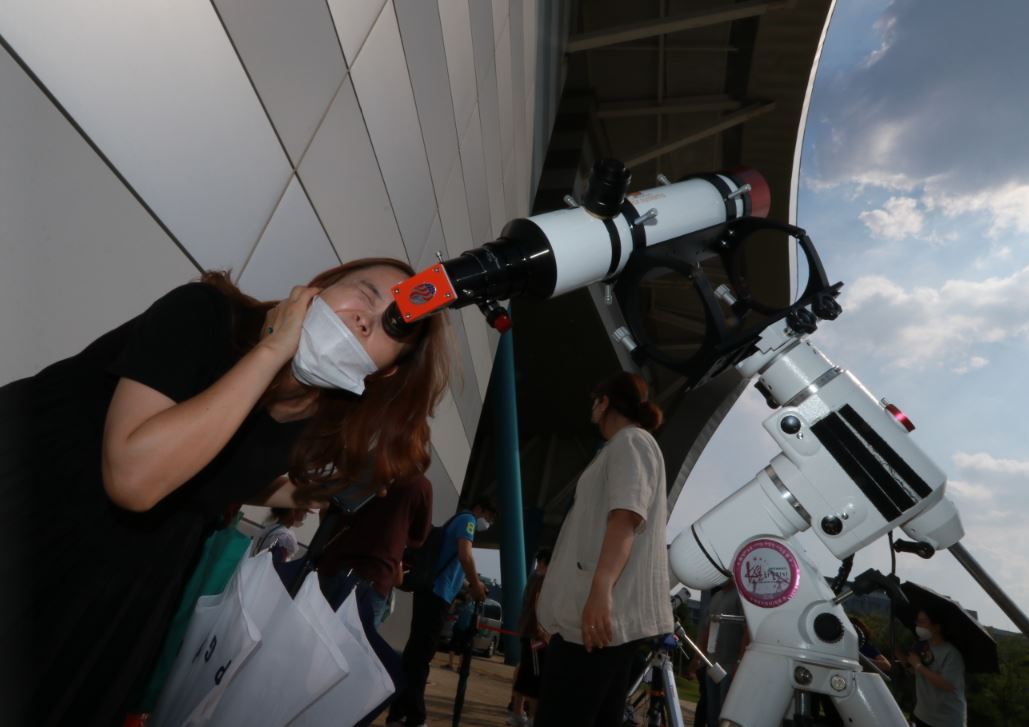 남녀노소가 태양 관측 안경을 쓰거나 특수 망원경으로 부분일식을 관측했다. <사진=국립광주과학관 제공>
