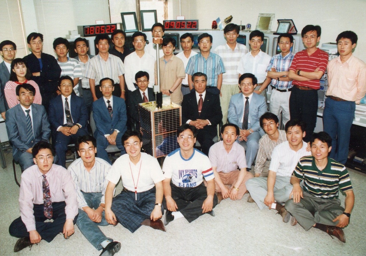 1992년 우리별을 쏘아 올린 연구팀 단체 사진. 가운데 위성 오른쪽 빨간 넥타이를 맨 이가 한국 인공위성의 아버지인 고 최순달 박사다. 그 위에 서있는 이가 박성동 전 의장. [사진=대덕넷DB]