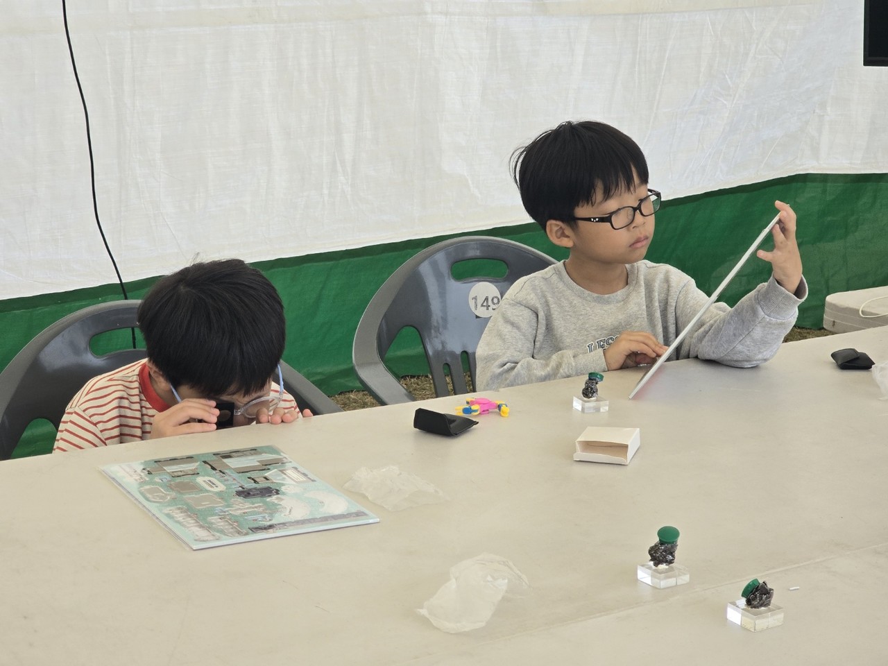 운석을 돋보기로 관찰하는 아이. "운석 연구를 이렇게 할 수 있구나~" [사진=김지영 기자]